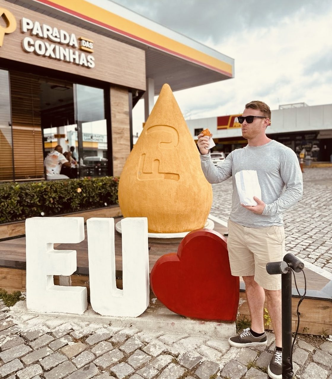 Tyler comendo uma coxinha na Parada das Coxinhas